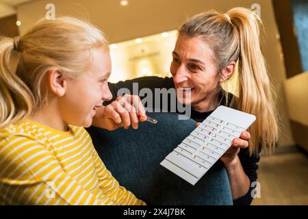 Fröhliche Mutter und Tochter, die Ohrringe in einem Juweliergeschäft aussuchen Stockfoto