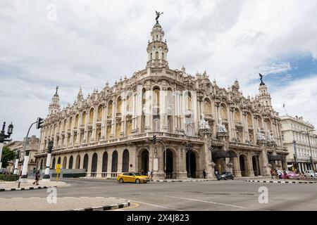 HAVANNA, KUBA - 28. AUGUST 2023: Gebäude des Gran Teatro de La Habana in Havanna, Kuba, gelbes Taxi auf der Straße Stockfoto