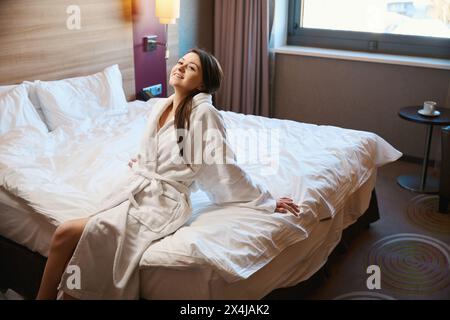 Fröhliche Frau, die nach dem Aufwachen im Hotelzimmer Zeit verbringt Stockfoto