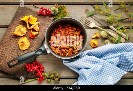 Cantharellus cibarius, allgemein bekannt als Pfifferlinge, goldene Pfifferlinge oder girolle. Pilze mit Butter. Stockfoto