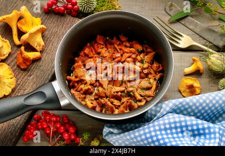 Cantharellus cibarius, allgemein bekannt als Pfifferlinge, goldene Pfifferlinge oder girolle. Pilze mit Butter. Stockfoto