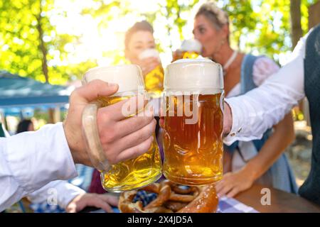 Im bayerischen Biergarten toasten, Nahaufnahme der Gläser Stockfoto