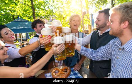 Freunde genießen Essen und Trinken im bayerischen Biergarten an einem sonnigen Tag Stockfoto