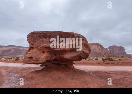 Eine große Hoodoo-Formation entlang einer unbefestigten Straße im Monument Valley zeigt Millionen von Jahren Erosion durch Wasser und Wind. Stockfoto