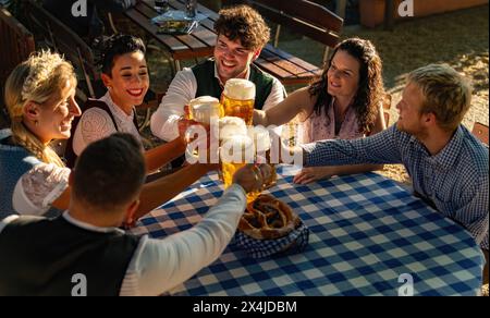 An einem sonnigen Tag genießen Menschen im bayerischen Biergarten Essen und Trinken Stockfoto