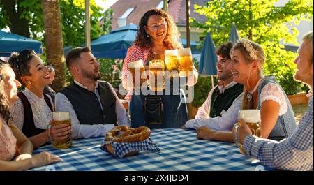 Kellnerin, die Bierbecher an die Gäste des Biergardens oder des oktoberfestes in Bayern, Deutschland, holt. Stockfoto