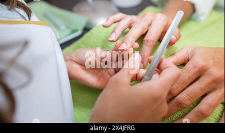 Maniküre, die die Nägel des Kunden in einem Nagelsalon behandelt Stockfoto