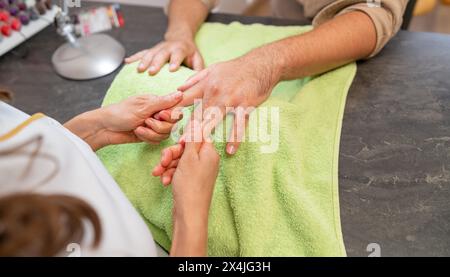 Maniküre, die die Hand des Kunden während einer Maniküre massiert. Bild des Konzepts der Körperpflege-Spa-Behandlung Stockfoto