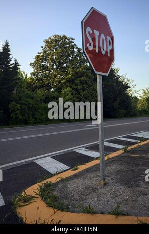 Stoppschild an einer Kreuzung einer Landstraße bei Sonnenuntergang Stockfoto