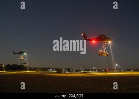 Fort Campbell, Kentucky, USA. April 2024. UH-60 Blackhawk Helicopters vom 5. Bataillon, 101. Combat Aviation Brigade, 101. Airborne Division (Air Assault), die Infanterie-Squad-Fahrzeuge zum Ziel als Teil eines großräumigen Luftangriffs während der Operation Lethal Eagle 24.1, 24. April 2024, auf Fort Campbell, Ky. Der großräumige Luftangriff (L2A2) ermöglicht es der 101. Luftlandedivision (Air Assault), hochgradig tödliche, niedrige Signaturen und zusammenhängende Kampftruppen von verstreuten Orten aus schnell zu konzentrieren, um Gegner an einem Ort und zu einem Zeitpunkt unserer Wahl zu überwältigen. L Stockfoto