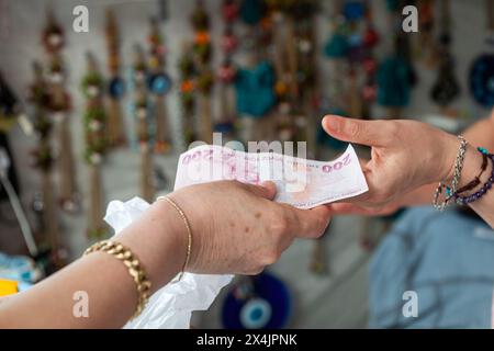 Die Frau, die dem Verkäufer 200 türkische Lira gab. Stockfoto