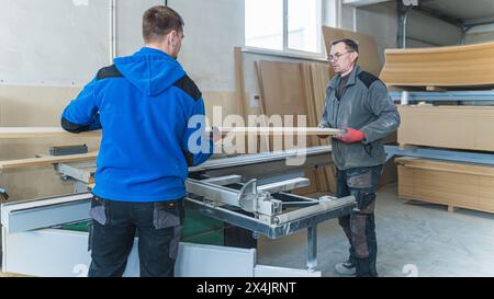 Zwei Zimmerleute arbeiten gemeinsam an Holz in Arbeits-, Industrie- und heimwerkerkonzepten. Hochwertige Fotos Stockfoto