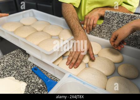 Hände, die Pizzateigbällchen berühren, Restaurant-Küche. Hochwertige Fotos Stockfoto