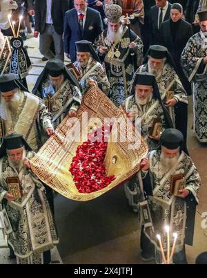 Eine Gruppe von Bischöfen, die eine Decke mit der Ikone Jesu tragen, bedeckt mit Rosenblumen. Hinter ihnen befindet sich der Patriarch Theophilos III. Von Jerusalem. Die Prozession ist Teil der Epitaphios-Zeremonie in der Grabeskirche. Quelle: Yoram Biberman/Alamy Live News. Stockfoto