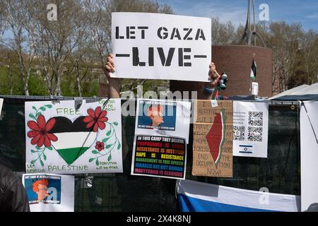 Ein pro-palästinensischer Demonstrant hält während einer Demonstration ein Plakat mit der Aufschrift "Lass Gaza leben" hoch. Hunderte nahmen an einer Pro-Israel-Kundgebung Teil, die vom New England Chapter des Israeli American Council auf den Stufen des Eingangs des mit an der Massachusetts Avenue organisiert wurde. Die Kundgebung war eine der größten Gegenproteste, die in der Nähe eines College-Campings in Boston stattfand. Die Kundgebung war etwa 30 bis 40 Meter vom pro-palästinensischen Lager auf dem Campus des mit entfernt. Die Polizeipräsenz war hoch in der Gegend und Metallbarrikaden wurden aufgestellt, um die beiden Seiten vor jeglichen Zusammenstößen zu bewahren. Ein paar israelische Unterstützer wandern durch Stockfoto