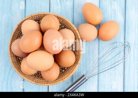 Frische Eier in einem Holzkorb auf Holzboden Stockfoto
