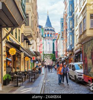 Istanbul, Türkei - 13. Mai 2023: Beliebtes Touristenziel Galata Tower, aus der engen und atmosphärischen kopfsteingepflasterten Buyuk Hendek Street Stockfoto