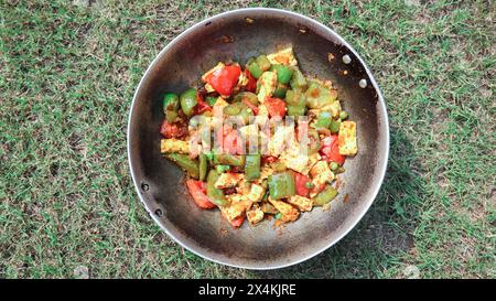 Leckere Paneer Chili Veg Pfannkuchen Beilage. Hausgemachtes Hüttenkäsegericht mit sautierten grünen und roten Paprika mit grünen Erbsen Stockfoto