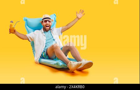 Mann, der sich auf aufblasbarer Matratze mit Cocktail entspannt Stockfoto