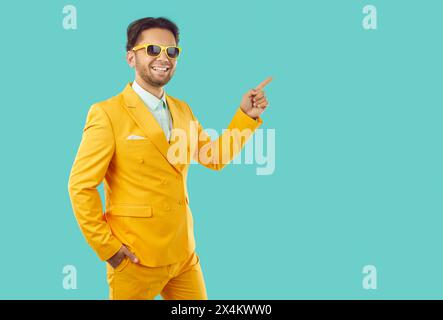 Porträt eines stilvollen jungen Mannes, der mit dem Finger auf den Kopierraum zeigt Stockfoto