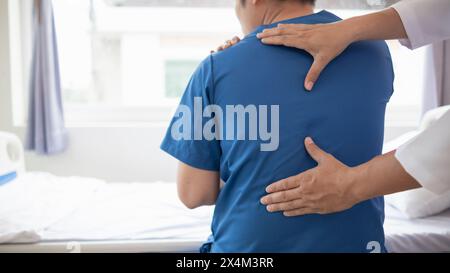 Der Mann wurde zur Behandlung von Muskelschmerzen im Schulterrücken wegen harter Arbeit und Muskelentzündungen zugelassen. Der Arzt behandelt den Mann musc Stockfoto