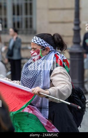 Eine Frau trägt einen Keffiyeh-Schal und eine blutbefleckte Maske während eines Pro-Palästina-Protestes, der von Schülern vor dem Pantheon in Paris geführt wurde. In einem Zeichen der Solidarität mit Palästina versammelten sich französische Gymnasiasten und Universitätsschüler vor dem Pantheon in Paris, verurteilten die anhaltende Gewalt in Gaza und forderten ein Ende dessen, was sie als Völkermord bezeichneten. Der friedliche pro-palästinensische Protest wurde mit der Anwesenheit der Polizei getroffen, die auch einen nahe gelegenen Pro-Israel-Gegenprotest leitete. Flaggen, Zeichen und Gesänge erfüllten die Luft, während beide Seiten ihre Sichtweise zum Ausdruck brachten Stockfoto