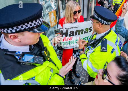 London, Großbritannien. Mai 2024. Eine kleine Gruppe von Pro-Israel-Demonstranten versucht, sich unter die Menge zu mischen (mit Pl;acards, die sagen, Hamas seien Terroristen, genug ist genug anbd Hamas=Isis), sie werden von der Polizei gebeten, die palästinensischen Demonstranten nicht zu konfrontieren - Ein palästinensischer Protest, Aufruf zu einem Waffenstillstand und Beendigung der Bewaffnung von Israel Palästina Protest an der Barclays Bank Tottenham Court Road. Die Demonstranten sagen, Barcalys sei "einer der größten Geldgeber des Waffenhandels mit Israel". Guy Bell/Alamy Live News Stockfoto