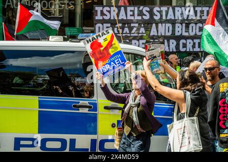 London, Großbritannien. Mai 2024. Eine kleine Gruppe von Pro-Israel-Demonstranten versucht, sich unter die Menge zu mischen (mit Pl;acards, die sagen, Hamas seien Terroristen, genug ist genug anbd Hamas=Isis), sie werden von der Polizei gebeten, die palästinensischen Demonstranten nicht zu konfrontieren - Ein palästinensischer Protest, Aufruf zu einem Waffenstillstand und Beendigung der Bewaffnung von Israel Palästina Protest an der Barclays Bank Tottenham Court Road. Die Demonstranten sagen, Barcalys sei "einer der größten Geldgeber des Waffenhandels mit Israel". Guy Bell/Alamy Live News Stockfoto