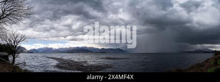 Panorama des Lago Maggiore an einem regnerischen Tag mit schweren niedrigen Wolken, die einen Teil der Küste bedecken - Reise- und Urlaubskonzept Stockfoto