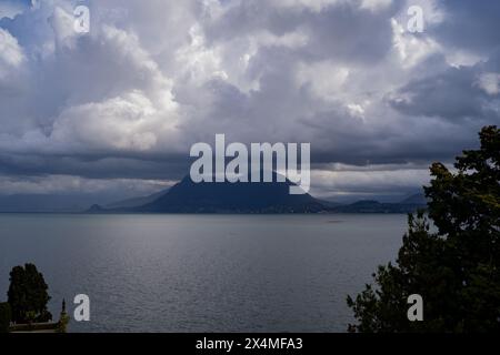 Panorama des Lago Maggiore an einem regnerischen Tag mit schweren niedrigen Wolken, die einen Teil der Küste bedecken - Reise- und Urlaubskonzept Stockfoto