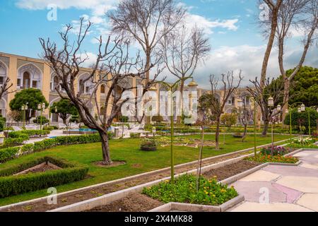 Abbasi Hotel, Iran - 4. März 2024: Üppige Gärten und klassische persische Architektur unter heiterem Himmel. Eine Oase der Ruhe im historischen Isfahan. Stockfoto