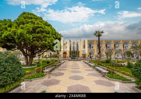 Abbasi Hotel, Iran - 4. März 2024: Üppige Gärten und klassische persische Architektur unter heiterem Himmel. Eine Oase der Ruhe im historischen Isfahan. Stockfoto