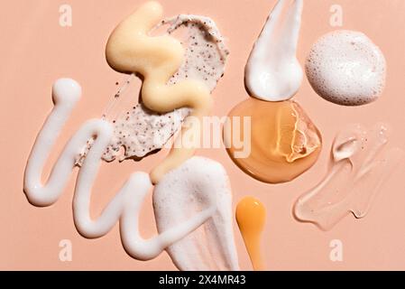 Kosmetikprodukte, Gel und Creme, auf beigefarbenem rosa Hintergrund. Beauty-Produkte für Gesichts- und Körperpflege: Feuchtigkeitscreme, Serum-Essence, reinigt Stockfoto