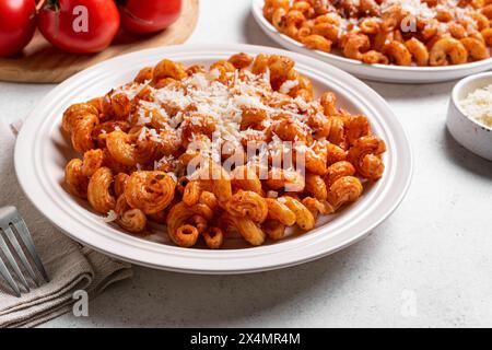 Cavatappi-Pasta mit Tomatensauce und geriebenem Parmesankäse aus nächster Nähe. Teller mit hausgemachter vegetarischer Pasta mit reichhaltiger roter Sauce. Stockfoto