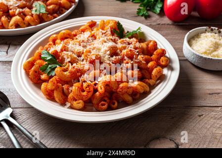 Cavatappi-Pasta mit Tomatensauce und geriebenem Parmesankäse aus nächster Nähe. Hausgemachte vegetarische vegane Pasta mit reichhaltiger roter Sauce. Stockfoto