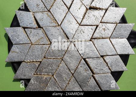 Kaju Katli indische Süßigkeiten Hintergrund mit silberner Varakfolie. Blick von oben auf Kaju Katli aus Cashewnüssen und mava Stockfoto