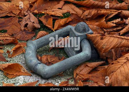 Friedhof Türknauf auf einem Grabdeckel, bedeckt mit einem gelben Blatt, Mirogoj Friedhof in Zagreb, Kroatien Stockfoto