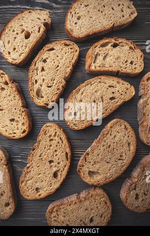 Blick von oben auf verschiedene Scheiben von frisch gebackenem Brot auf einem rustikalen hölzernen Hintergrund Stockfoto