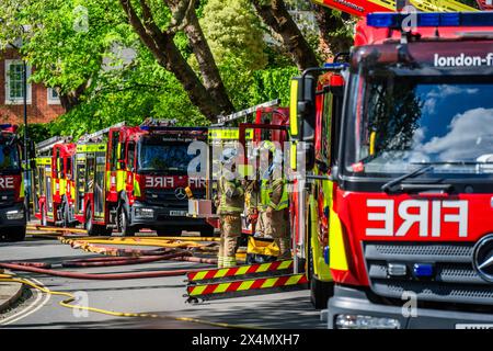 London, Großbritannien. Mai 2024. Viele Feuerwehrfahrzeuge, Krankenwagen und Polizisten nehmen bei einem Brand in einem großen Haus an der Elsworthy Road im Gebiet von Primrose Hill Teil. Das Feuer scheint klein gewesen zu sein und ist aus und die Notfallteams beginnen sich zu zerstreuen, während die vertriebene Familie zusieht. Zehn Feuerwehrfahrzeuge und etwa 70 Feuerwehrleute reagierten. Die Hälfte des zweiten Obergeschosses in einem freistehenden Haus mit drei Stockwerken wurde durch den Brand beschädigt. Eine der 32 m hohen Leiter der Brigade wurde zusammen mit Feuerwehrleuten aus West Hampstead, Paddington, Kentish Town eingesetzt. Credit Guy Bell/Alamy Live News Stockfoto