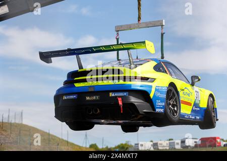 Oschersleben, Deutschland. April 2024. Porsche 911 GT3 Cup Team Proton Huber Wettbewerb gebrochen nach Unfall beladen mit Abschleppwagen Sicherheitsdienst Stockfoto