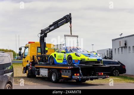 Oschersleben, Deutschland. April 2024. Porsche 911 GT3 Cup Team Proton Huber Wettbewerb gebrochen nach Unfall beladen mit Abschleppwagen Sicherheitsdienst Stockfoto