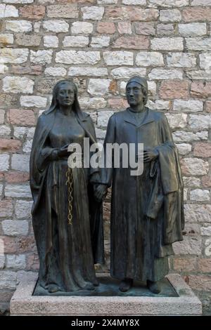 Die Statue von Peter und Giovanna Bernardone, den Eltern des hl. Franz von Assisi, von Robert Joppolo steht auf der Piazza Chiesa Nuova vor dem Chi Stockfoto