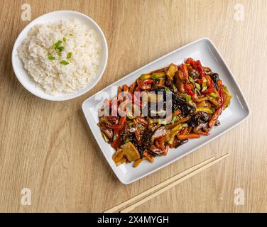 Leckeres asiatisches Gericht mit buntem Gemüse, serviert mit weißem Reis Stockfoto