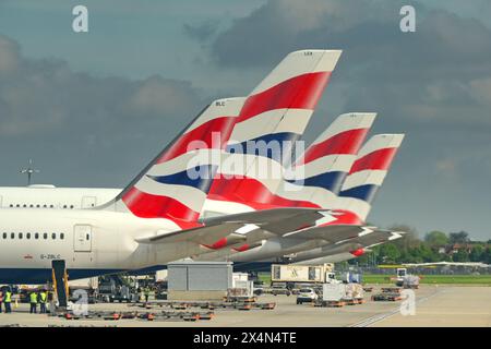 London, England, UK - 4. Mai 2024: Reihe von Heckflossen von Flugzeugen, die von British Airways am Flughafen London Heathrow betrieben werden. Stockfoto