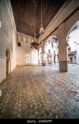 Besucher erkunden das historische Cherratine Madrasa in der geschäftigen Medina von Fezs. Stockfoto