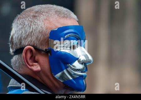 Glasgow, Schottland, Großbritannien. Mai 2024. Ein Unterstützer der schottischen Unabhängigkeit mit einer Saltire-Maske marschiert vom Kelvingrove Park durch das Stadtzentrum zu einer Kundgebung in Glasgow Green. Die Veranstaltung wurde von der Gruppe All Under One Banner organisiert. Quelle: Skully/Alamy Live News Stockfoto