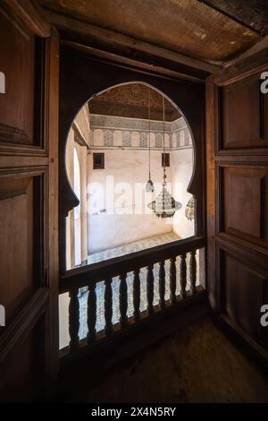 Ein ruhiger Blick fängt das Wesen von Fès durch das verzierte Fenster von Cherratine Madrasa ein. Fès, Marokko. Stockfoto