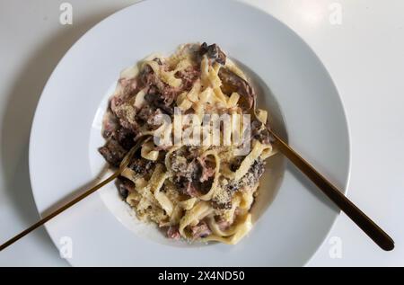 Tagliatelle Nudeln in einer Sahnesauce mit Schinken und Pilzen Stockfoto