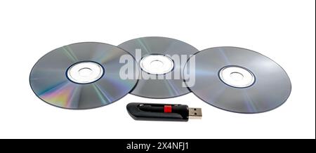 Horizontale Nahaufnahme von drei CDs und einem USB-Flash-Laufwerk mit hoher Kapazität auf weiß. Stockfoto