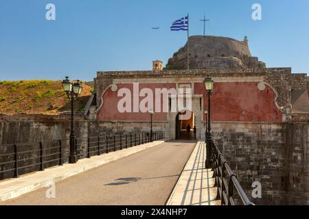 Brücke, die zum Eingang der alten Festung in Kerkyra, Korfu, Griechenland führt, griechische Flagge winkt darüber Stockfoto